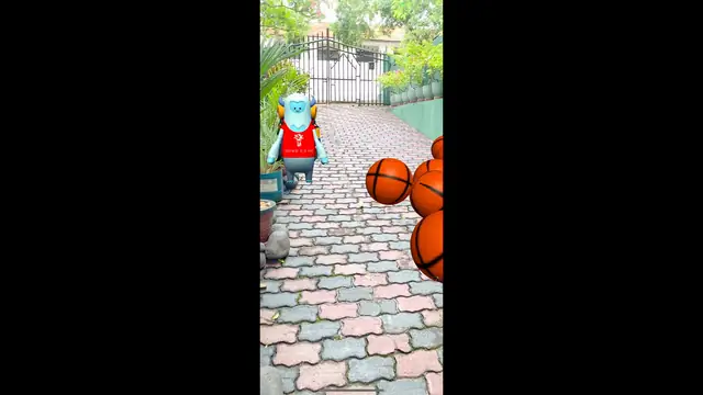 A virtual character and floating collectible objects placed along a real paved outdoor walkway